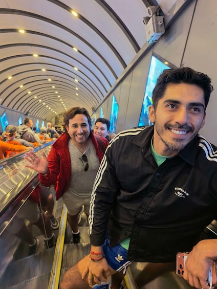 Una persona en una escalera mecánica con techo curvo e iluminación colgante. 3