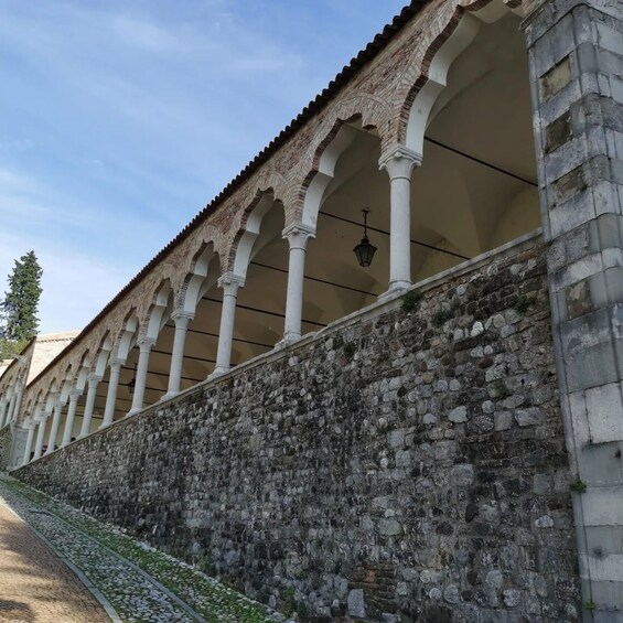 A stone wall with a series of arches and a tiled roof. 2