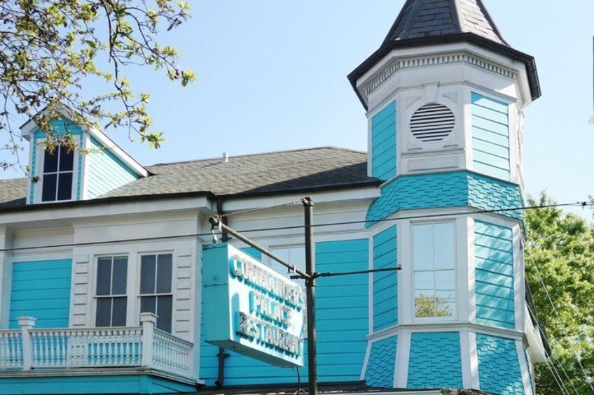 A turquoise and white building with a tower and a sign that reads 'Cottage Inn.' 4