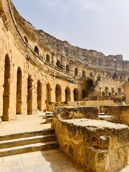 Un antiguo anfiteatro de piedra con escalones y múltiples arcos. 1