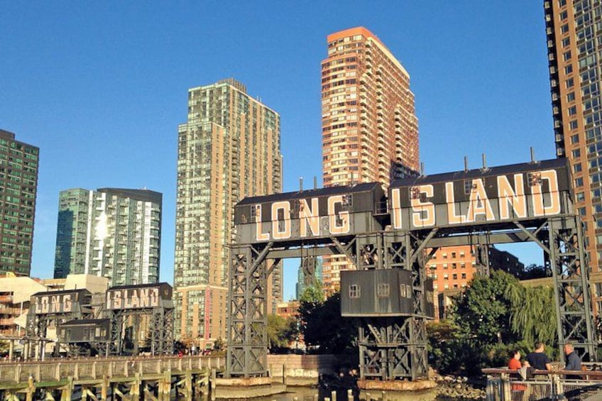 A cityscape with a prominent sign reading 'LONG ISLAND' and several high-rise buildings in the background. 1