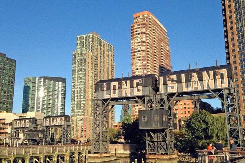 A cityscape with a prominent sign reading 'LONG ISLAND' and several high-rise buildings. 1