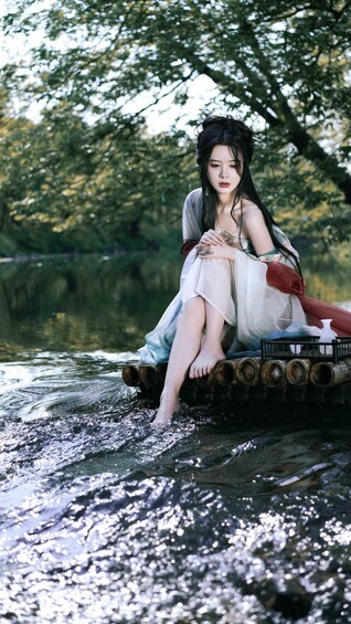 A person sitting on a boat in a body of water surrounded by trees. 3