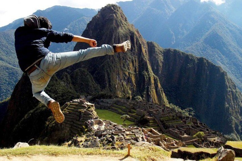 A person jumping in front of Machu Picchu with mountains in the background. 3