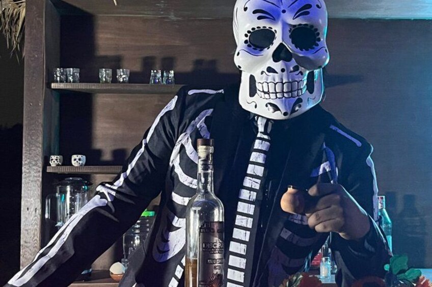 A person in a skeleton costume holding a bottle. 1