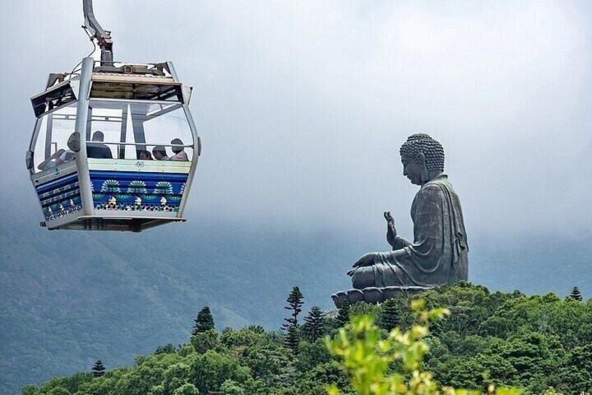 A large Buddha statue, a cable car, and a mountainous landscape. 1