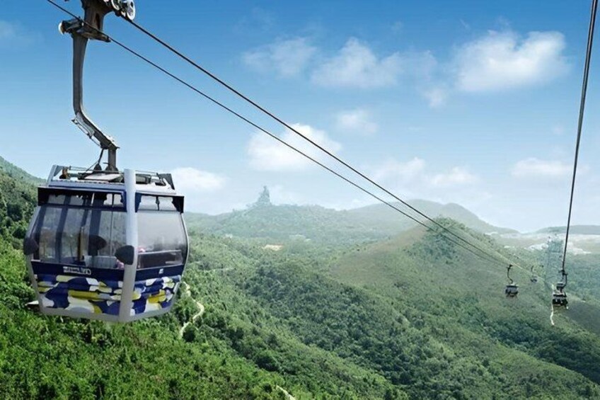 A cable car system in a mountainous area with lush greenery and distant hills. 4
