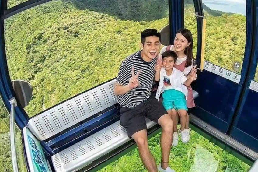 A family on a cable car with a lush green landscape below. 3