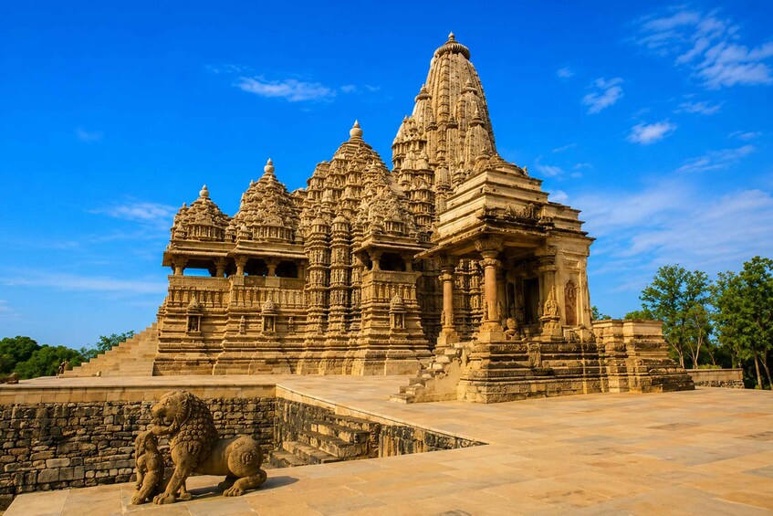 A large, intricately carved temple with multiple spires and a lion statue in the foreground. 4