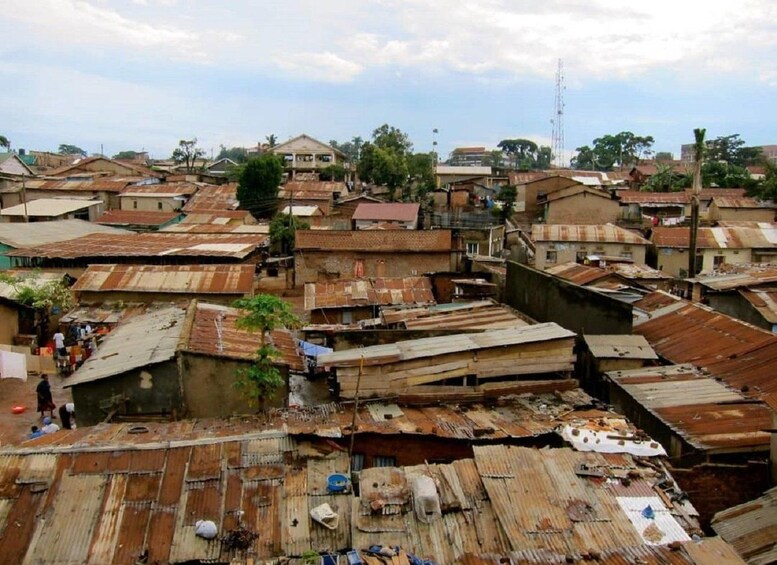 Una zona urbana densamente poblada con numerosos edificios, algunos con techos de metal corrugado, y algunas personas visibles al frente. 4
