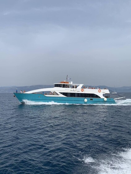 A large yacht cruising on a calm sea with a mountainous backdrop. 2