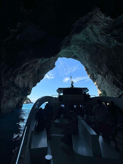 A boat inside a cave with a clear view of the sea and sky. 5