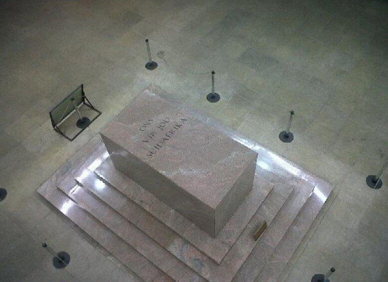 Un monumento de piedra con inscripciones, rodeado de estructuras metálicas. 3