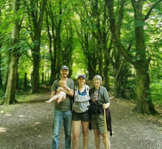 A family of four in a forested area with a dirt path. 4