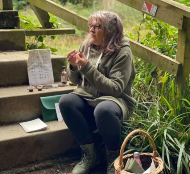A person sitting on outdoor steps with a calendar, a notebook, and a basket. 5