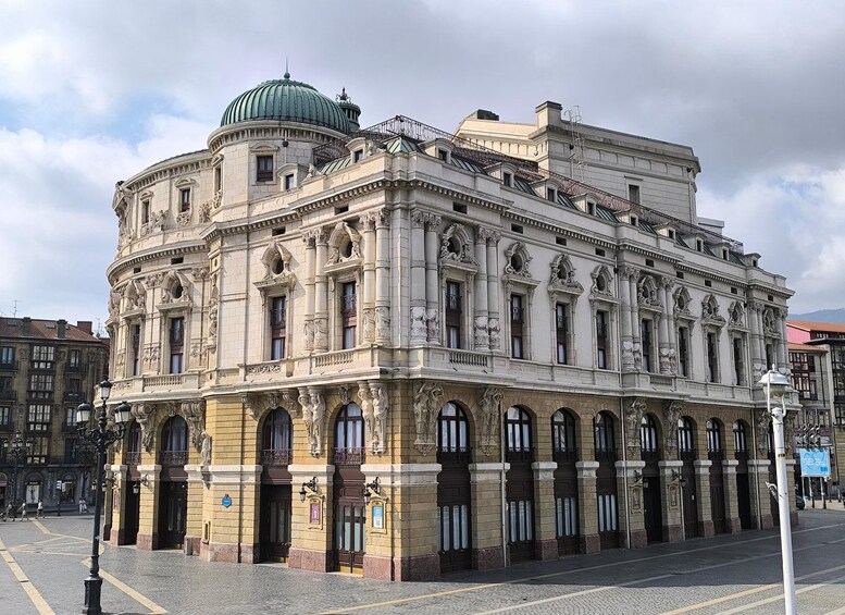 Un edificio histórico con arquitectura ornamentada, que incluye una cúpula y detallados grabados. 3