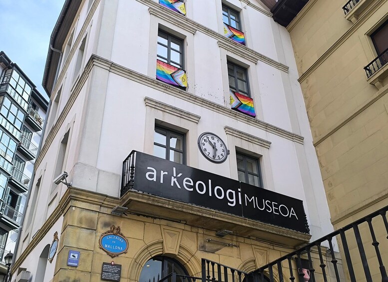 Un edificio con un cartel que dice 'Arkeologi MUSEO' y un reloj. 1