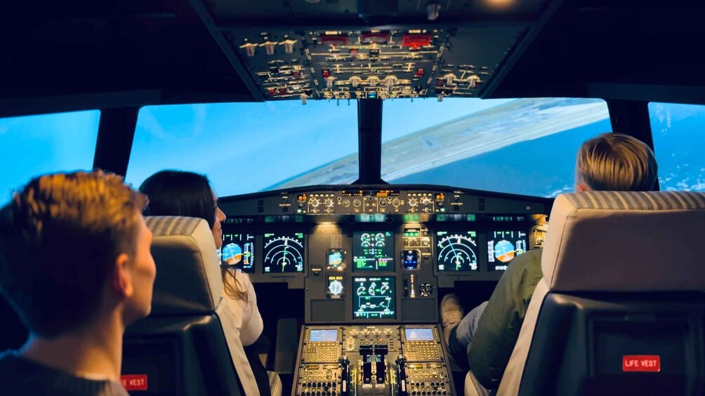 The cockpit of an airplane with multiple screens and controls. 1
