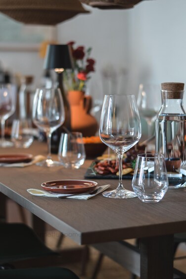 Una mesa de comedor con diferentes vasos, platos y un candelabro. 1