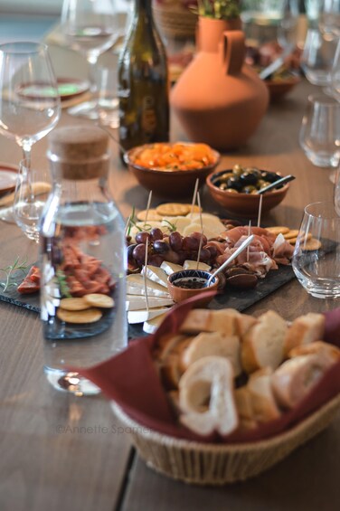 Una mesa con diversos alimentos, como quesos, embutidos y aceitunas. 2