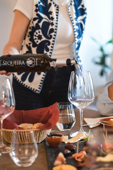 Una persona sirviendo vino en una copa. 3