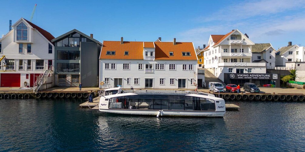 A white boat docked at a pier with a building labeled 'Viking Adventure' in the background. 1