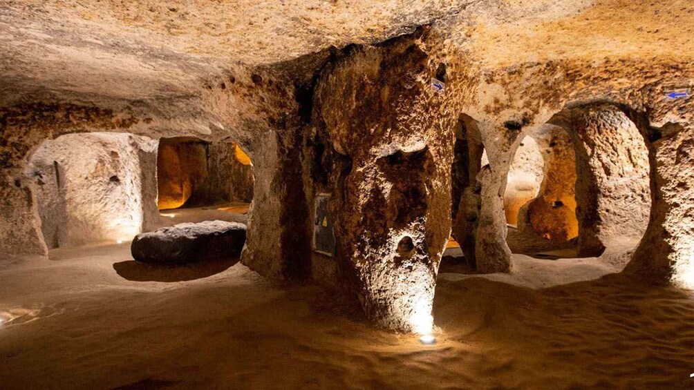 Eine Höhle mit Stalaktiten und Stalagmiten, beleuchtet durch künstliches Licht. 4