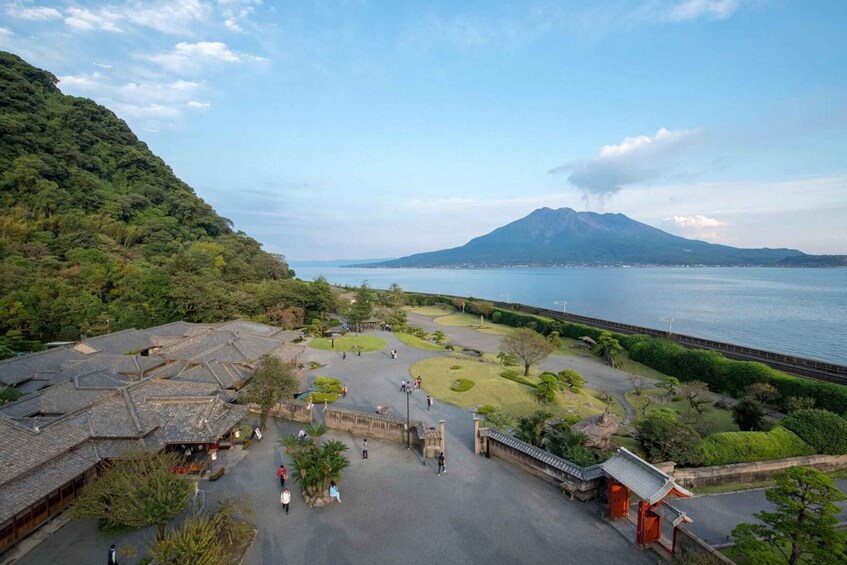 A traditional Japanese temple complex with a view of a volcano and a body of water. 3