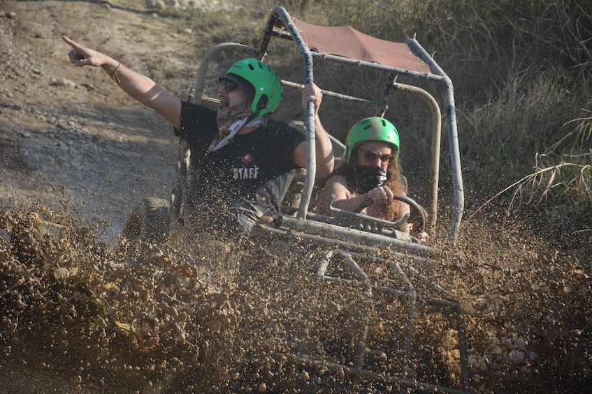 Dos personas en un vehículo por un camino de tierra rodeado de vegetación seca. 5