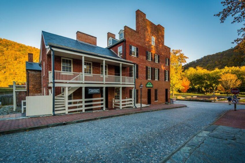 A historic building with a balcony, a stop sign, and a paved street. 3