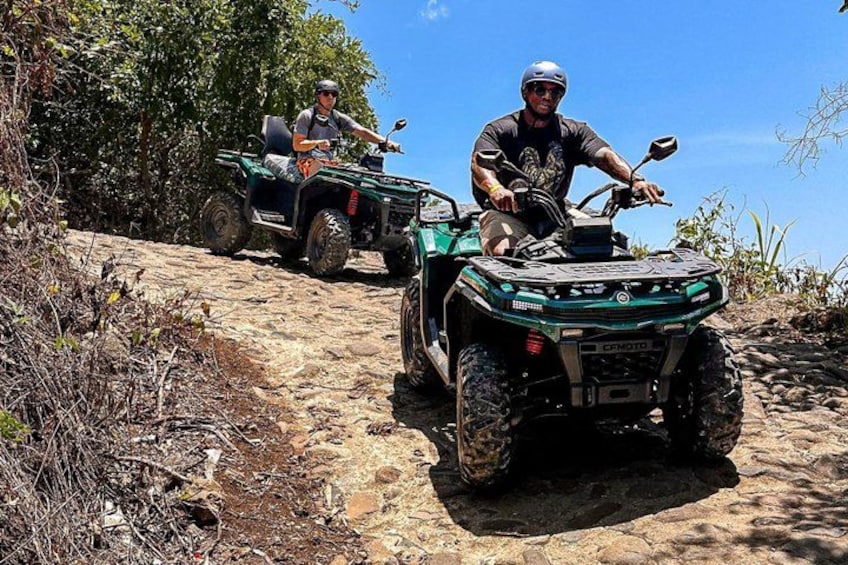 Two people on ATVs on a rocky trail. 1