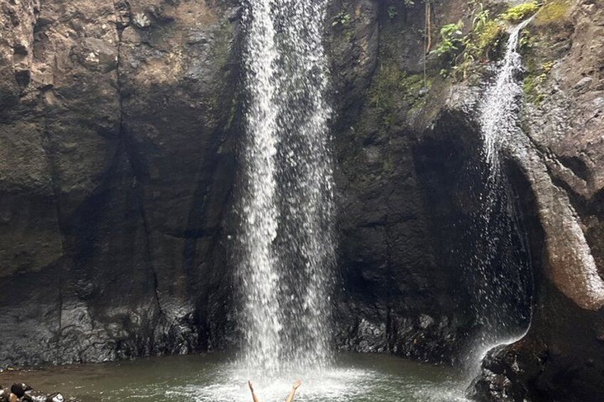A waterfall cascading down a rocky cliff into a pool. 3