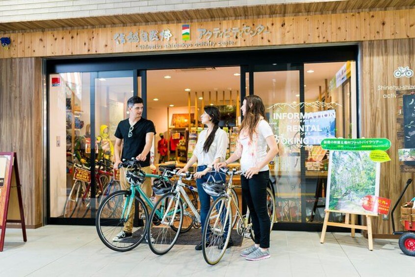 A bicycle rental shop with bicycles outside and a signboard. 5