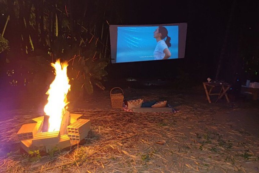 A campfire, a television screen, and a tent in an outdoor setting. 3