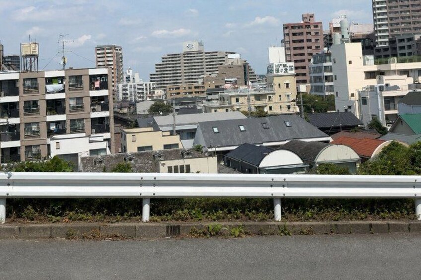 A cityscape with modern buildings, a bridge, and a road. 5