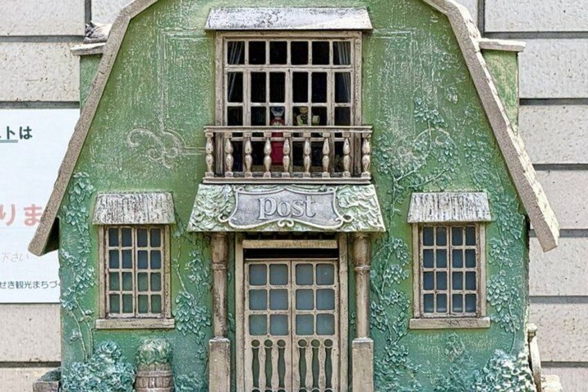A green building with a balcony and a sign that reads 'Post'. 2
