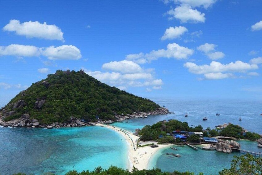 A tropical island with a beach, clear turquoise waters, and a small dock. 5