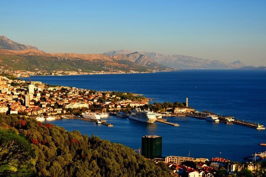 A coastal town with a marina, boats, and a mountainous backdrop. 4