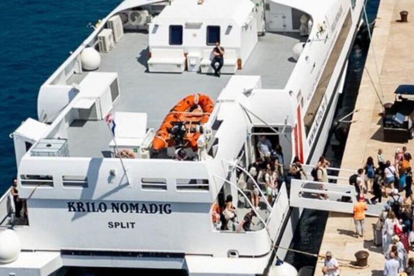 A large white ship named 'KRILO NOMADIG SPLIT' with people on deck and a lifeboat. 5
