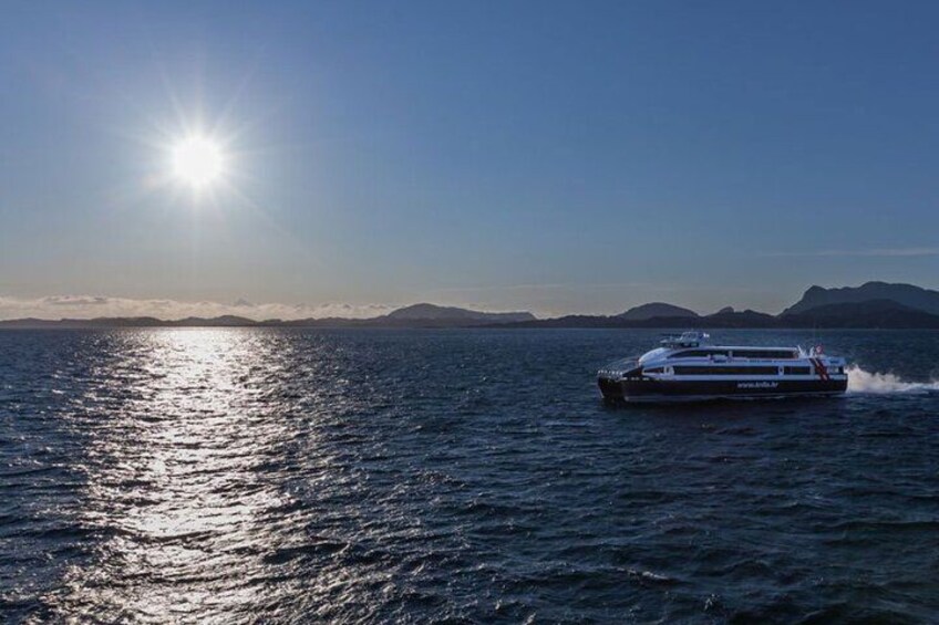 A cruise ship sailing on a calm sea with the sun reflecting off the water. 1