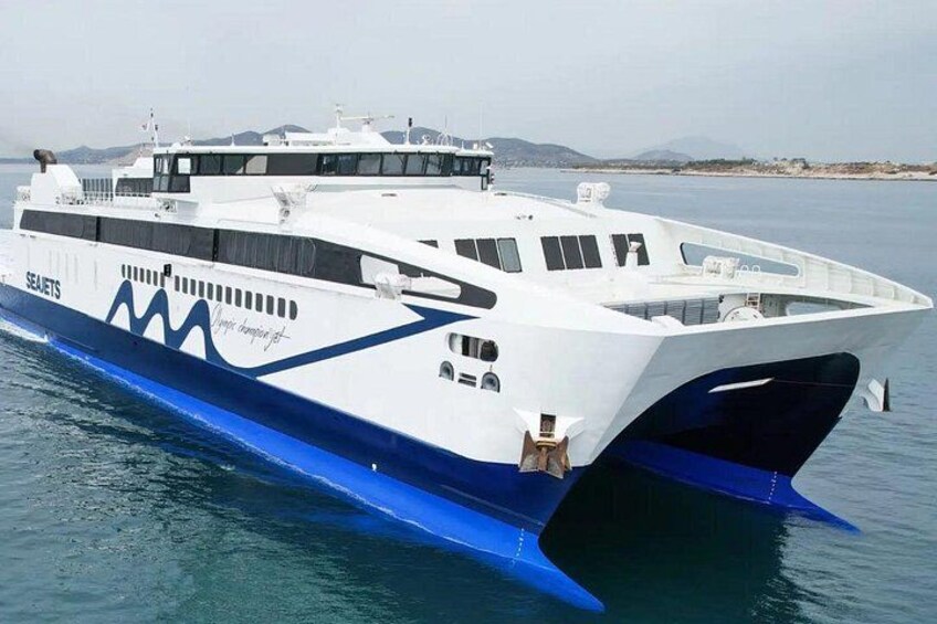 A large white and blue yacht with the name 'SEAJETS' on its side, sailing on calm waters with a mountainous coastline in the background. 1