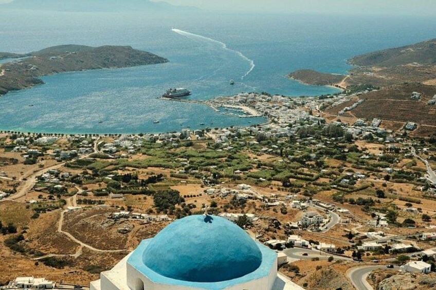 A coastal town with a prominent blue-domed building, a winding road, and a ship in the distance. 3