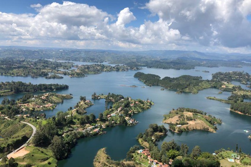 A lake surrounded by greenery and small islands. 1