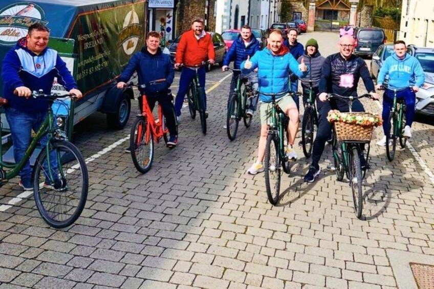 A group of people riding bicycles on a cobblestone street. 4
