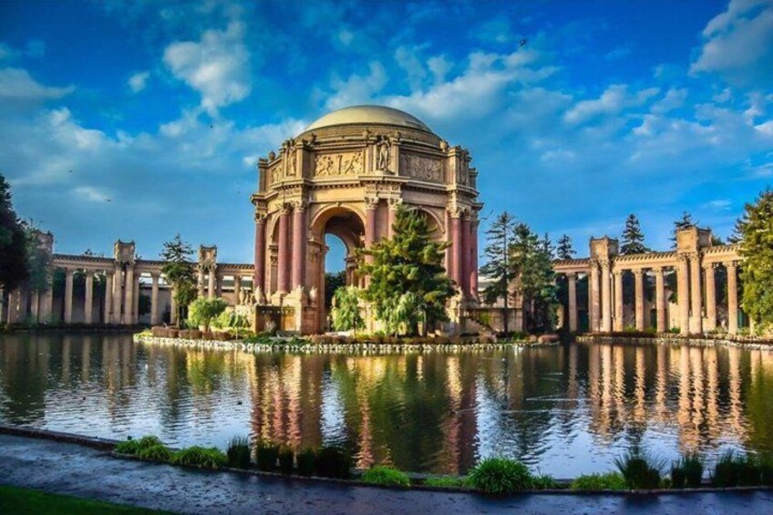 A historic building with a large dome and arches, surrounded by a body of water and greenery. 2