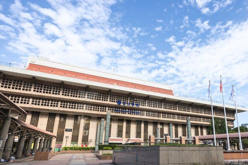 A large, multi-story building with a flat roof and a series of columns in front. 2