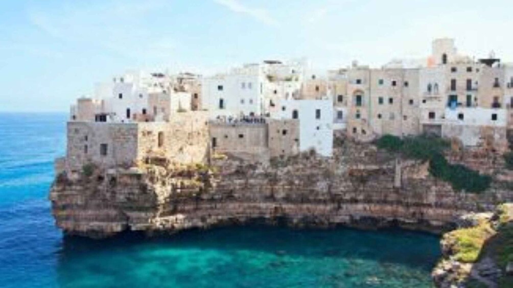 Eine Küstenstadt, die an einer Klippe erbaut wurde, mit klarem, blauem Wasser darunter. 5