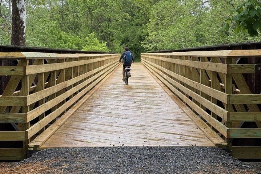 A wooden bridge with a cyclist in the distance. 2