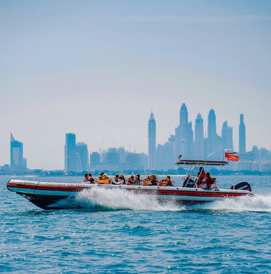 A speedboat with passengers, speeding across a body of water with a city skyline in the background. 5