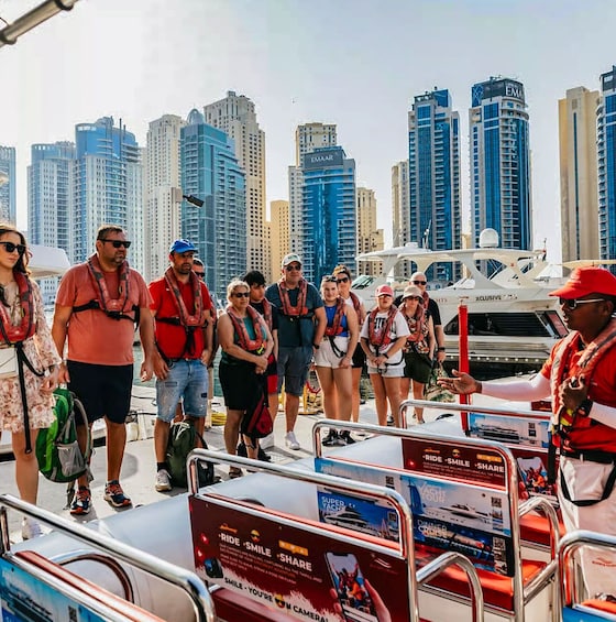 A group of people on a boat with a city skyline in the background. 4